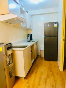 a kitchen with a black refrigerator and a wooden floor at Seawind in Davao City
