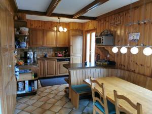 a kitchen with wooden cabinets and a wooden table and chairs at Le balcon de Mâche in Hérémence