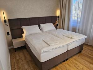 a large bed with white sheets and white pillows at Balónový hotel a pivovar Radešín in Radešín +122 photos