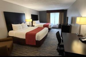 a hotel room with two beds and a desk at Comfort Inn & Suites Tampa North I-75 in Tampa
