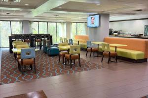 a waiting room with tables and chairs in a restaurant at Comfort Inn & Suites Tampa North I-75 in Tampa