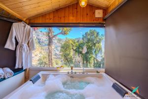 a jacuzzi tub in a room with a large window at Zostel Homes Mussoorie, Mall Road in Mussoorie