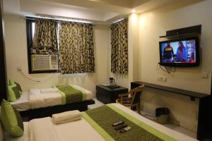 a hotel room with two beds and a flat screen tv at Hotel Lav Kush Deluxe 2 Min Walk From New Delhi Railway Station in New Delhi