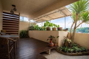 a balcony with potted plants and a wooden bench at Ban Ao Thong in Trang