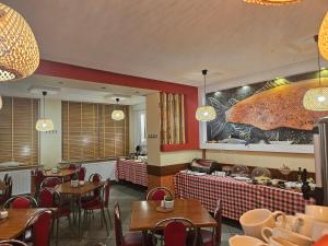 a restaurant with tables and chairs and a mural at "Hel" Wieniec Zdrój in Włocławek
