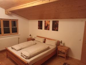 a bedroom with a large bed in a room with wooden ceilings at Fewo zum schwarzen Hirsch in Dalaas