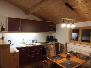 a kitchen with wooden cabinets and a wooden table at Fewo zum schwarzen Hirsch in Dalaas