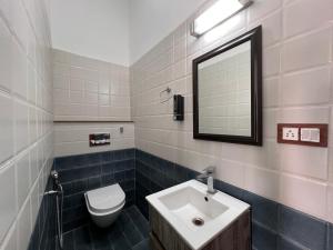 a bathroom with a sink and a toilet and a mirror at The Bougainvillea Retreat in Dehradun +134 photos