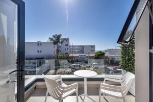 a balcony with a table and chairs and a view of a city at Bayview Hotel in Plettenberg Bay