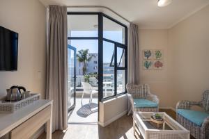 a living room with a view of a balcony at Bayview Hotel in Plettenberg Bay