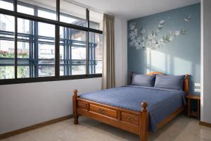 a bedroom with a bed and a window at My Friends Hotel in Trang