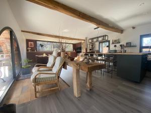 a kitchen and living room with a table and chairs at La Vieille Scierie in Basville