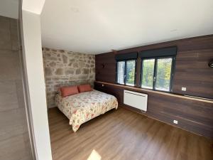 a bedroom with a bed and some windows at La Vieille Scierie in Basville