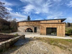 a large wooden building with a stone garage at La Vieille Scierie in Basville
