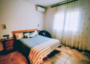 a bedroom with a bed with a striped blanket and a window at Can Carbó in Pals +34 photos