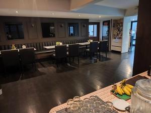 a dining room with a long table and chairs at The Wing Lanna Hotel in Chiang Mai