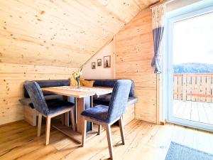 a dining room with a table and chairs and a window at Claras Bergzeit in Flattnitz