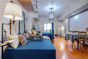a living room with a blue couch and a projection screen at 上海晶彩酒店式公寓江桥万达店 in Shanghai