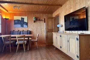 a dining room with a table and a flat screen tv at Chalet Mungg in Bettmeralp