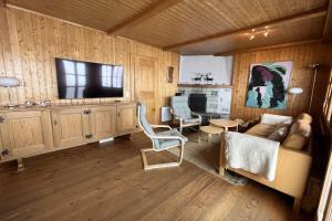 a living room with a couch and a table and a television at Chalet Mungg in Bettmeralp