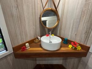 a bathroom with a sink and a mirror on a wooden counter at FARE VAVAE in Tevaitoa