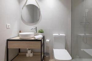 a bathroom with a sink and a toilet and a mirror at Valencia Marina Apartment near Beach & City of Arts in Valencia +15 photos