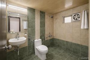 a bathroom with a toilet and a sink at Hotel Ashoka Mountabu in Mount Ābu +10 photos