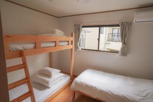 a bedroom with two bunk beds and a window at Tipy records inn HALO in Odawara