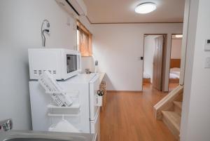 a kitchen with a white refrigerator and a microwave at Tipy records inn HALO in Odawara +83 photos