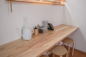 a wooden counter with stools in a kitchen at Tipy records inn HALO in Odawara