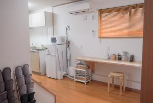 a kitchen with a white refrigerator and a counter at Tipy records inn HALO in Odawara