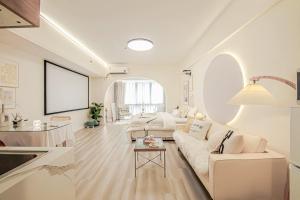 a white living room with a couch and a table at 上海晶彩酒店式公寓江桥万达店 in Shanghai