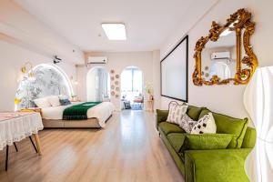 a living room with a bed and a green couch at 上海晶彩酒店式公寓江桥万达店 in Shanghai