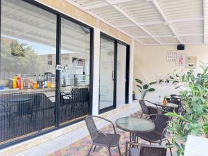 an outdoor patio with tables and chairs and windows at Kalandra Living in Yogyakarta
