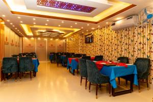 a restaurant with blue tables and chairs and a ceiling at Hotel Tawhid in Rangpur