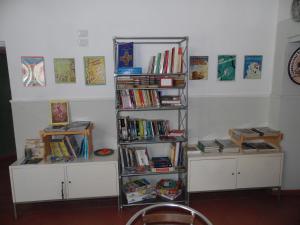a book shelf filled with books in a room at Agorà Hostel in Pompei