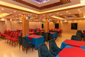 a banquet hall with red and blue tables and chairs at Hotel Tawhid in Rangpur