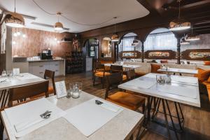 a restaurant with tables and chairs and a kitchen at Alp Pension in Bled
