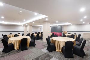 a conference room with tables and chairs and a screen at MAXONE Batam in Nagoya