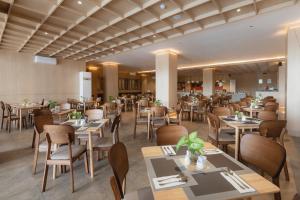 a restaurant with tables and chairs in a room at MAXONE Batam in Nagoya