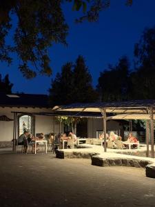 a group of people sitting at tables in a pavilion at Il Pampaleone Glamping and Resort in Acireale
