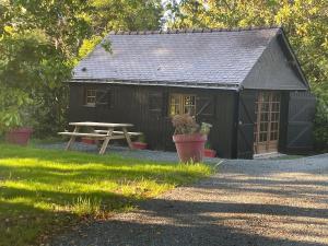 a black shed with a picnic table in front of it at Les logis du Landron in Plessé
