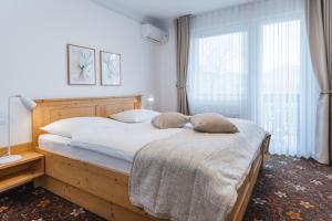 a bedroom with a large bed with two pillows on it at Alp Pension in Bled +65 photos