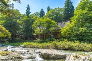 a cabin in the woods next to a river at Wanosato in Takayama +40 photos