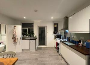 a kitchen with white cabinets and a counter top at Spacious 3-Bed Terrace, Great Links in Stowmarket