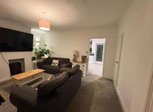 a living room with two couches and a tv at Spacious 3-Bed Terrace, Great Links in Stowmarket
