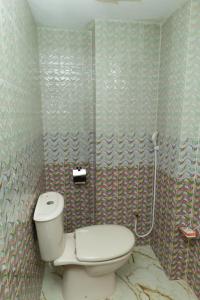 a bathroom with a toilet and a shower at Hotel Tawhid in Rangpur +68 photos