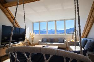 a living room with a couch and a swing at Niesen Loft in Spiez