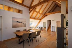 a dining room and living room with a wooden table and chairs at Niesen Loft in Spiez