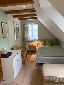 a bedroom with a bed and a desk in a attic at Pilemosegaard, lejlighed med 2 værelser in Roskilde